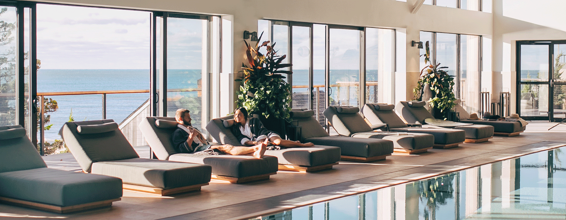 GIF showing couple lounging by indoor pool, waves crashing in front of pink skyline, shoreline view of Gurney's Montauk Resort & Seawater Spa.