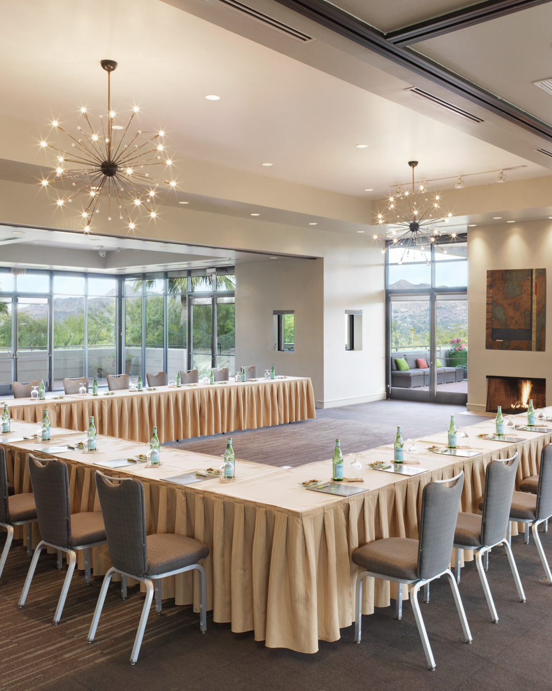 Views Ballroom with chandeliers, lit fireplace and u-shape meeting setup with banquet chairs.