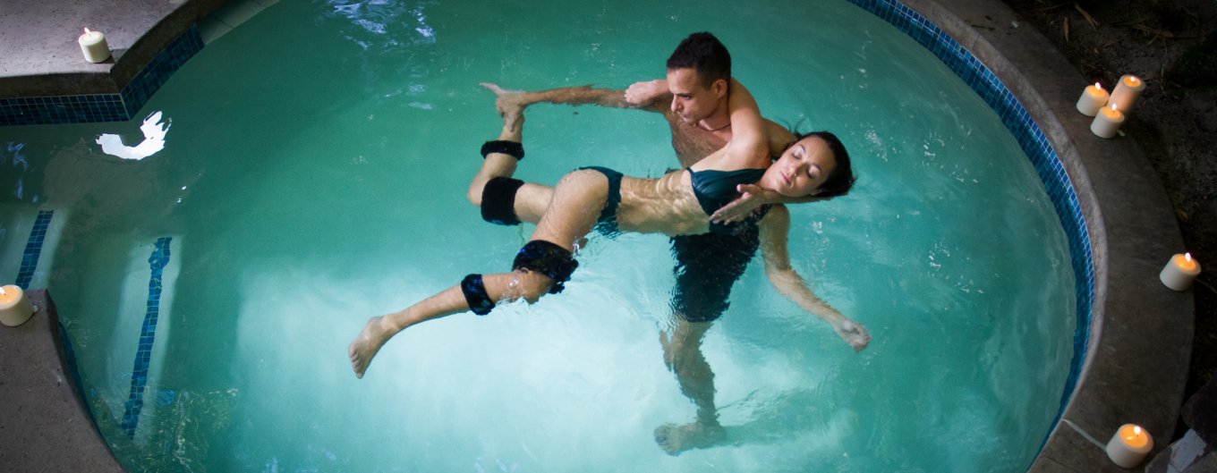 Woman in bathing suite being guided through water during Watsu Aquatic Treatment.