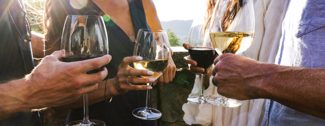 Two couples enjoying glasses of wine on elements Sunset Patio.