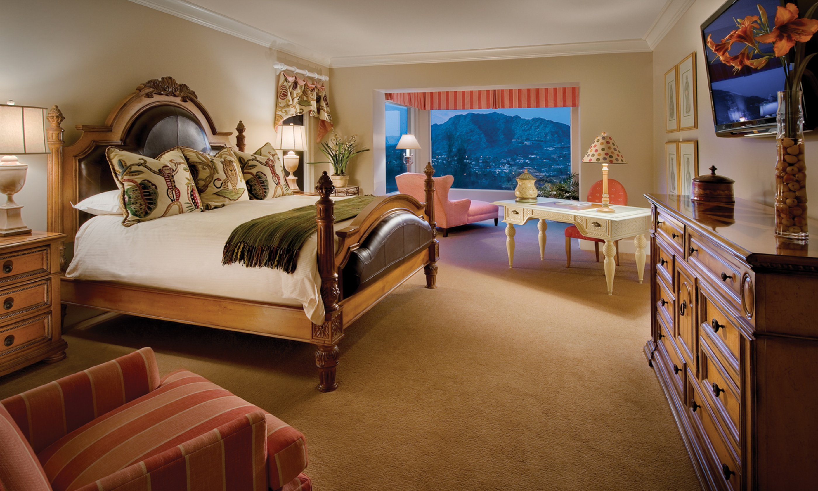 Bedroom with king bed, dresser, reading chair, writing desk and sitting area with valley views.