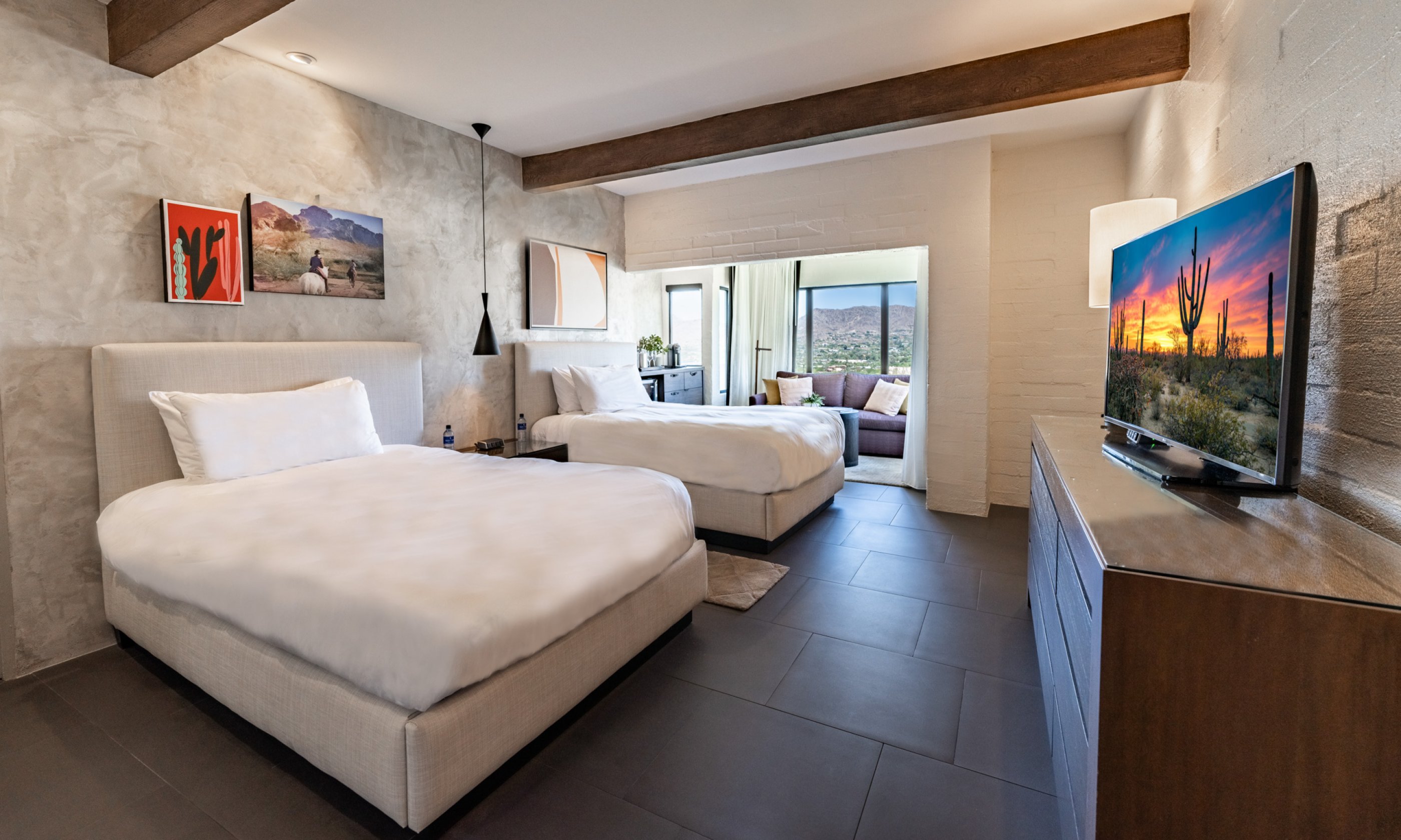 Mountain Casita with two double beds, flat screen television, nightstand, accent wall, comfortable couch and coffee table.