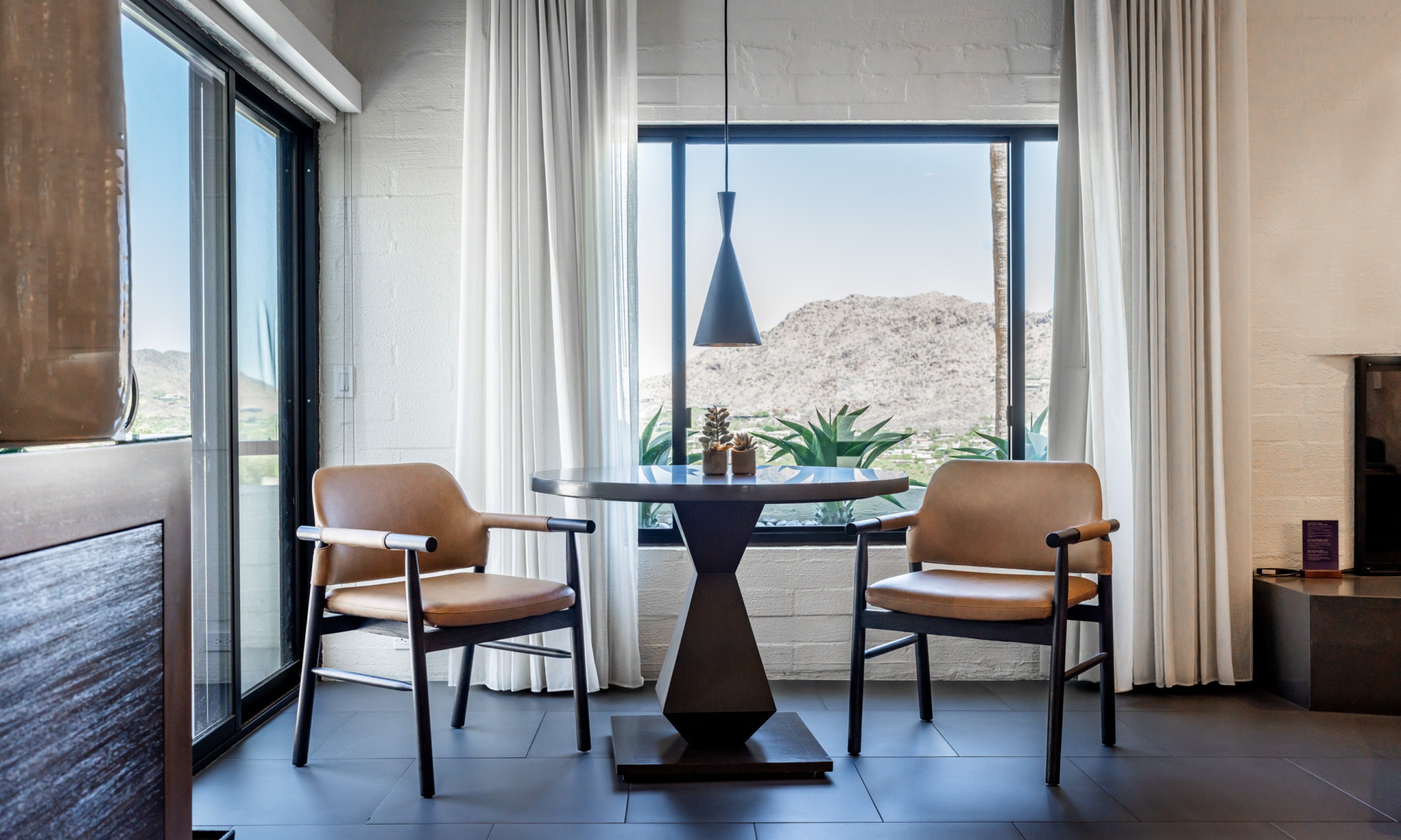 Seating area overlooking valley view with comfortable chairs and dining table.