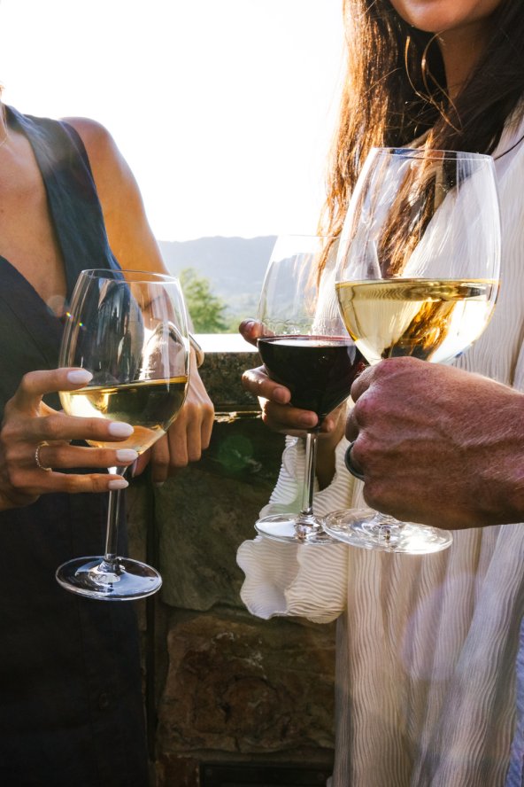 Two couples enjoying glasses of wine on elements Sunset Patio.