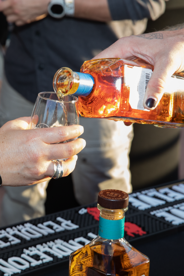 A closeup of a whisky pour into a small sample glass