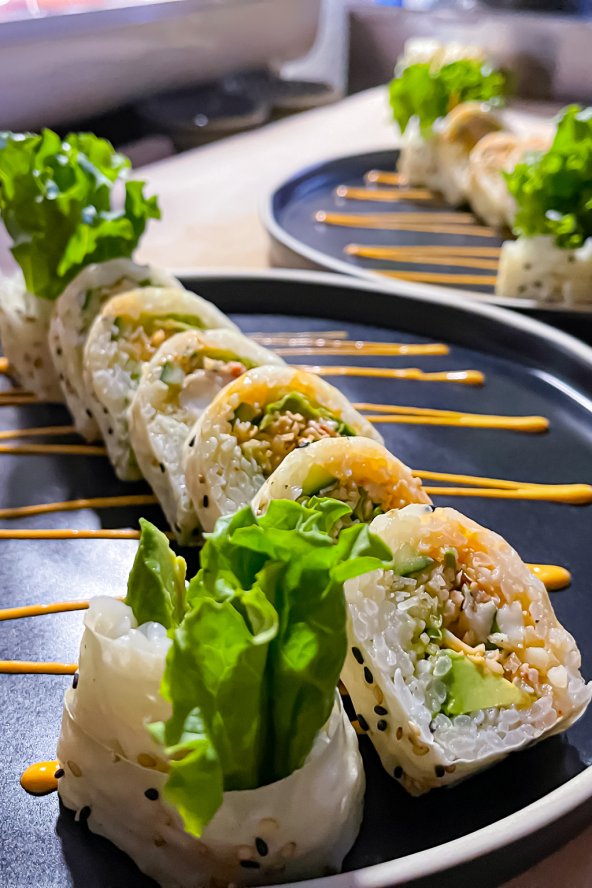 Two plates featuring colorful sushi rolls