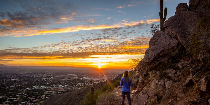 Woman watching sunset from Camelback Mountain.