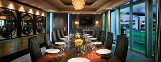 Elegant dining room with a long table set for 12, decorative chandelier, and modern decor.