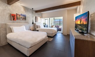 Mountain Casita with two double beds, flat screen television, nightstand, accent wall, comfortable couch and coffee table.